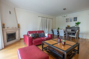 Un salon avec un canapé en cuir rouge, une table basse en bois et une cheminée.