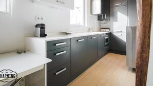 A modern kitchen with dark grey cabinets, a white countertop, and a built-in oven.