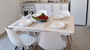 A modern kitchen with white cabinetry, a stainless steel range hood, and a built-in oven.