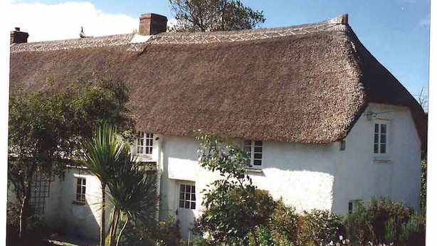 A white building with a thatched roof and multiple windows. - A beautiful 250 year old thatched cottage close to Frenchman's Creek. 2 bedrooms (Helston)