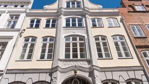Un edificio histórico con una entrada central, varias ventanas y una fachada decorativa.