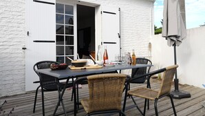 An outdoor dining area with a white building, a table set with chairs, and a pergola with a canopy. - 2-bedroom house, close to the beach, all on foot (L'aiguillon-Sur-Mer)