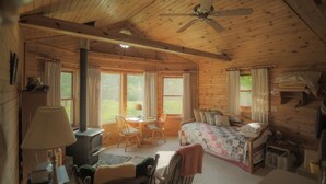 Een knus vakantiehuisje met houten inrichting, een bed, een bureau en een stoel.