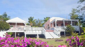 A two-story building with a covered porch and a staircase leading to the upper level. - Coconuts: Indoor/Outdoor Living, Spa, Heated Pool & Privacy! (St. John)