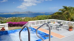 A hot tub on a deck with a view of the ocean and hills. - Coconuts: Indoor/Outdoor Living, Spa, Heated Pool & Privacy! (St. John)