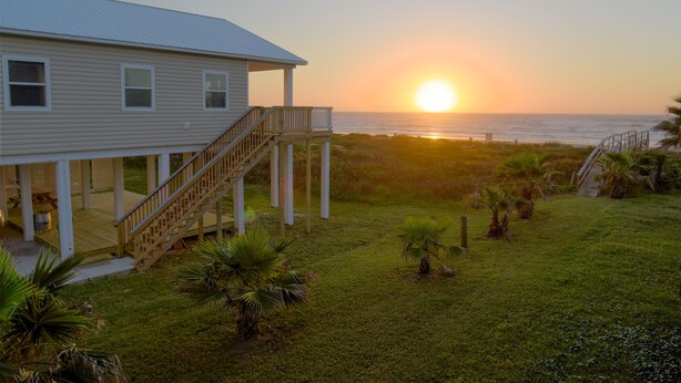 A house with a covered porch and a view of the sunset over the ocean. - Beachfront! 4bdr(3 kings)/3 bath/sleeps  17  (Surfside Beach)