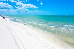 Une plage à l’eau turquoise et limpide et au sable blanc.