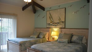 Une chambre avec deux lits, un tableau représentant un voilier et une fenêtre avec des stores.