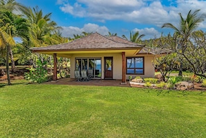 Uma casa com alpendre coberto, piscina e vista para o mar.