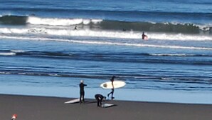 Une scène de plage avec des surfeurs et des planches de surf.