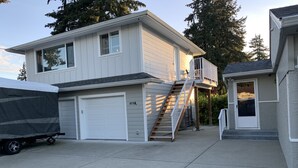 A two-story house with a covered garage and a small porch. - New Construction Coach House, 10 Minute Walk to Downtown and Ferry Spotless (Nanaimo)