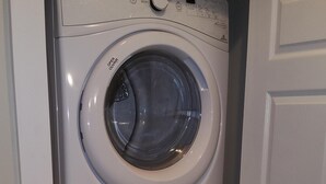 A stacked washer and dryer unit in a laundry room. - New Construction Coach House, 10 Minute Walk to Downtown and Ferry Spotless (Nanaimo)