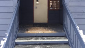 Een trap die leidt naar een deur met een nummerbord en een sleutelbos.