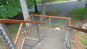 Un escalier en bois avec des rampes et une main courante en métal.
