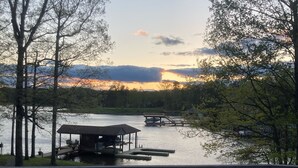 Une terrasse au bord du lac, avec un quai et un espace salon abrité.