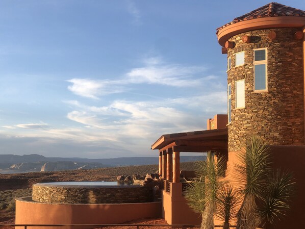 Un edificio de piedra con una torre circular y una piscina.