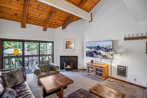 Cozy living room with a fireplace, large window, and comfortable seating area.