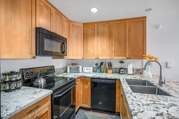 Fully equipped kitchen with appliances, sink, and ample storage.