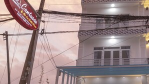 A two-story building with a sign for 'Mr. Lee Dalat House' and a gated entrance. - MrLee Dalathouse (Xuan Huong - Da Lat)