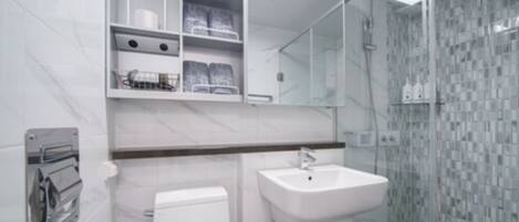 Ein modernes Badezimmer mit Toilette, Waschbecken und Duschkabine.