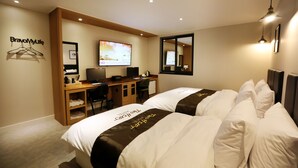 A hotel room with two beds, a desk, a television, and a mirror. - Two Heart Hotel (Daegu)