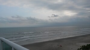 A beach with a view of the ocean and a cloudy sky. - Beachfront apartment (Praia Grande)