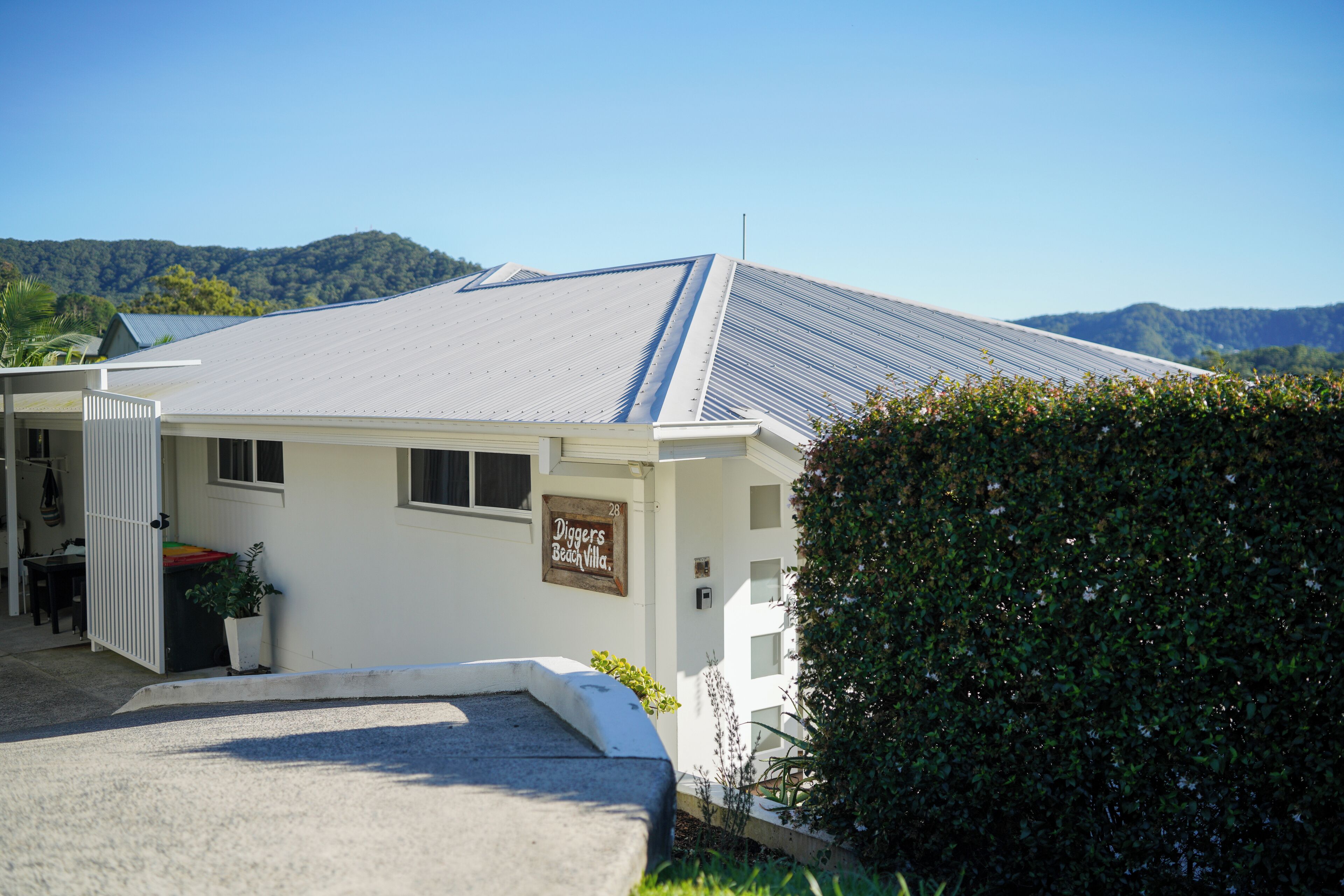 Un bâtiment blanc sur lequel on peut lire l’inscription : « Diggers Beach Villa ».