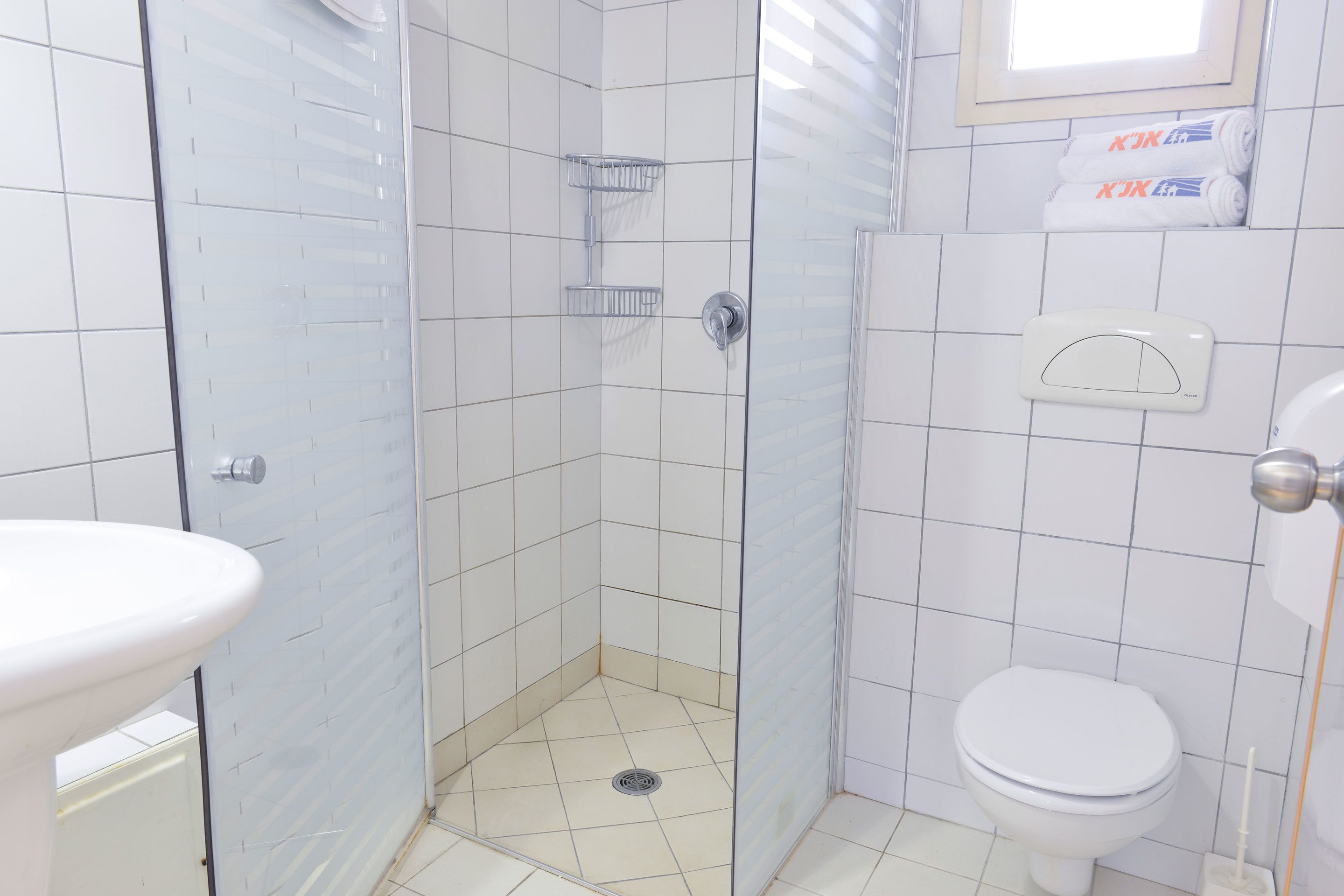 A bathroom with a shower, toilet, and sink.