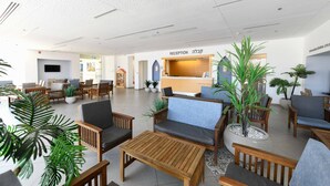A reception area with wooden furniture, potted plants, and a reception desk. - HI Eilat Hostel (Eilat)
