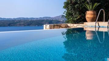 Una piscina al aire libre de temporada, sombrillas
