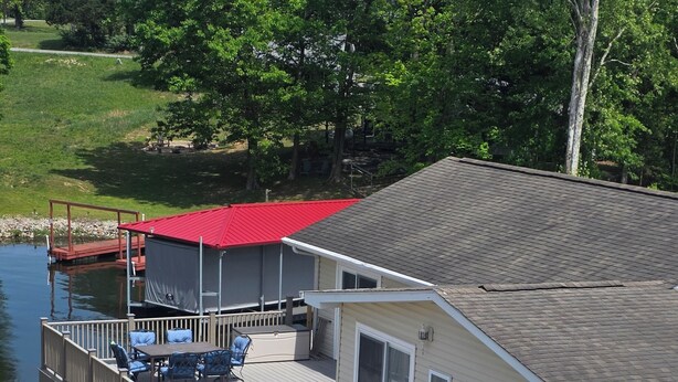 Une maison avec une terrasse, un espace couvert et une vue sur un lac.