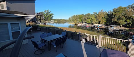 A deck with outdoor furniture overlooking a lake and docked boats.