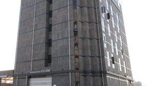 Un moderno edificio de hotel con un llamativo letrero que dice "HOTEL ECO STAY".