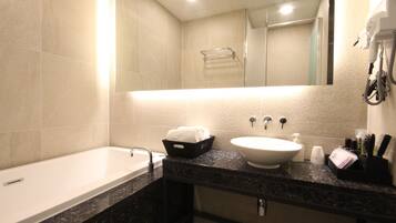 A modern bathroom with a bathtub, a sink, and a mirror.