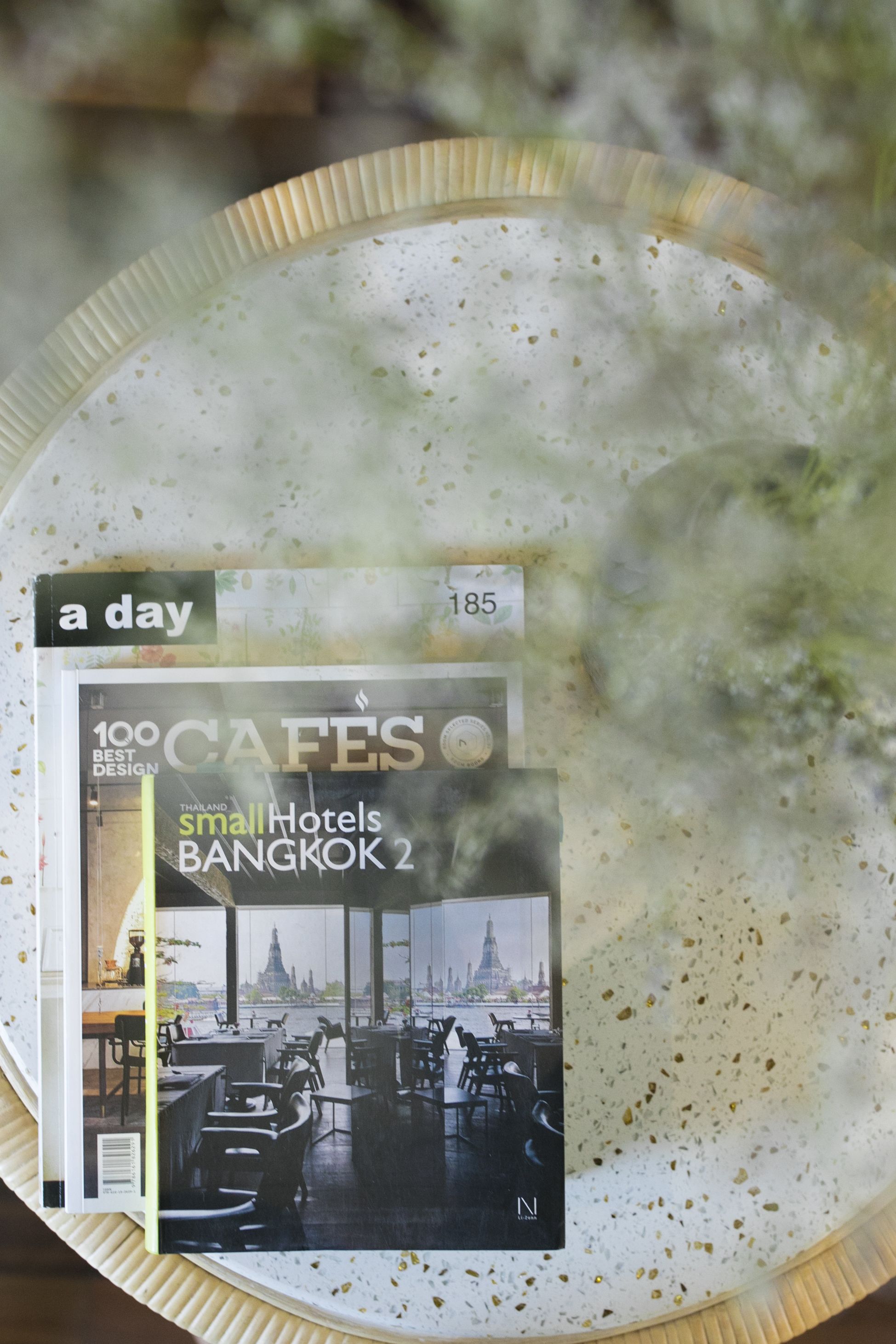Portada de revista con vista al interior de un café y el texto '100 CAFES' y 'Pequeños Hoteles BANGKOK 2'.