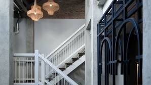Un escalier avec des rampes blanches et un mur de briques en arrière-plan.