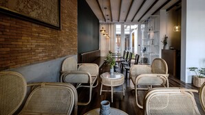 Un café chaleureux avec des meubles en osier, une carte accrochée au mur et un design moderne au plafond.