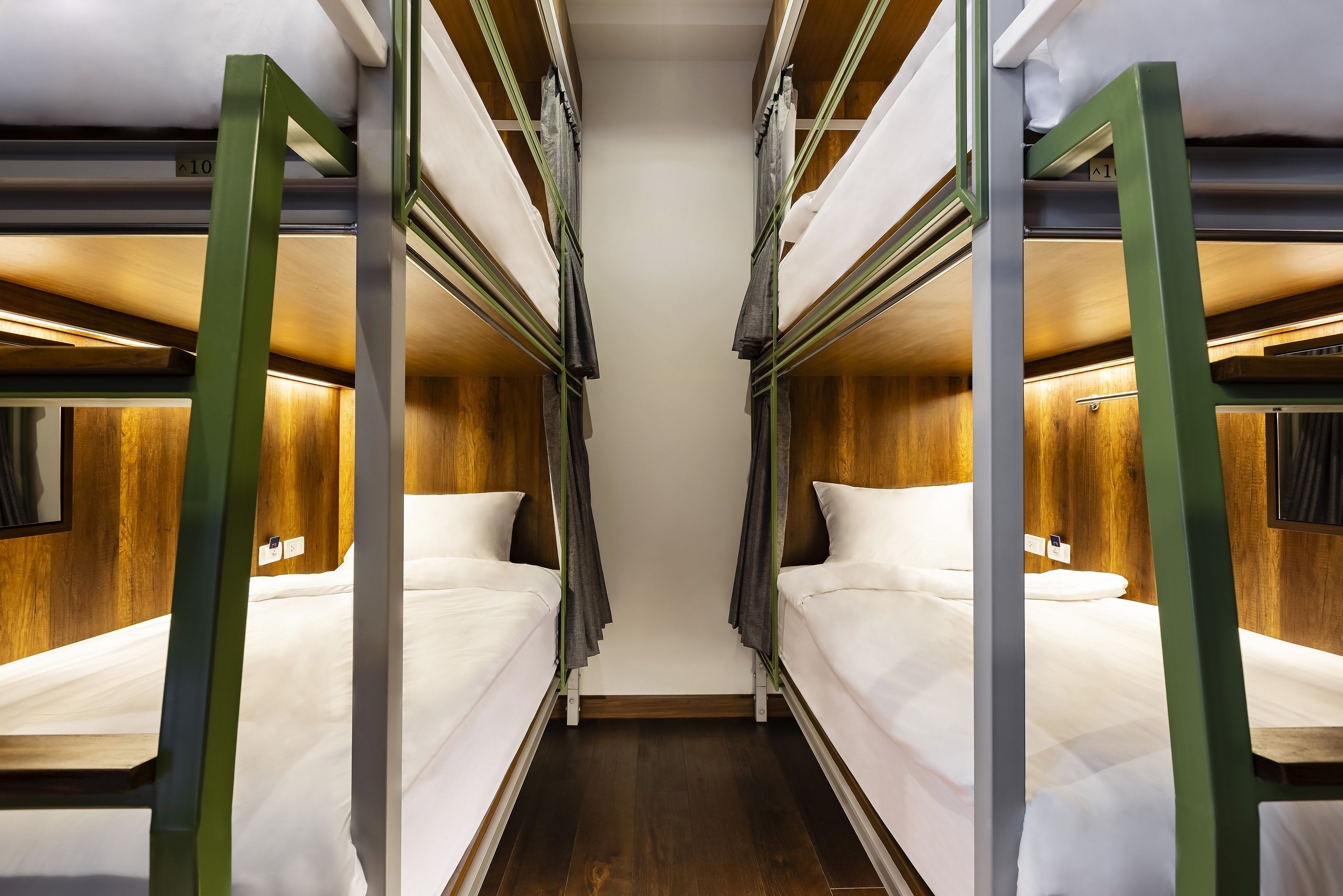 A narrow, enclosed train compartment with bunk beds, wooden paneling, and a small window.