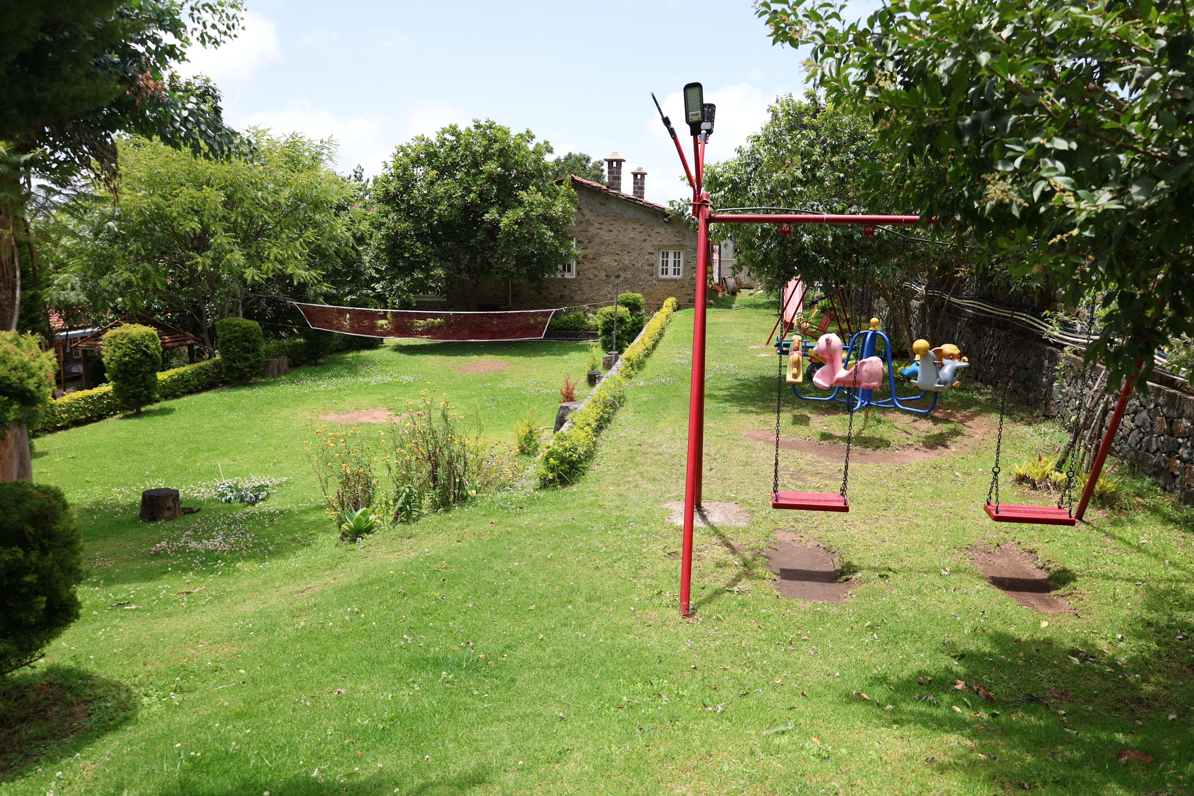 A playground with swings and a climbing structure.