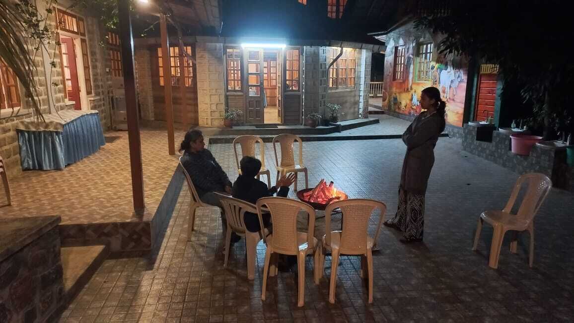 An outdoor seating area with wicker chairs and a small fire pit.