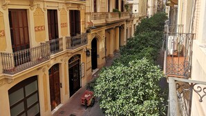 Une rue étroite bordée de bâtiments jaunes, chacun doté de balcons et de volets décoratifs.