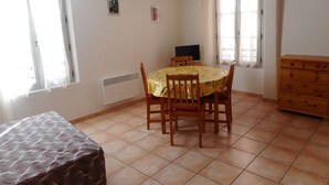 Un coin repas comprenant une table et des chaises, un radiateur et une commode.