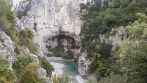 Un canyon traversé par une rivière, entouré de falaises rocheuses et d’une végétation luxuriante.
