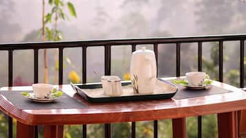 A wooden table with a tray holding a teapot, cups, and a sugar bowl.