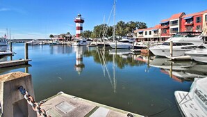 Ein Yachthafen mit vertäuten Booten, einem Leuchtturm und einem Gebäude mit Balkonen.
