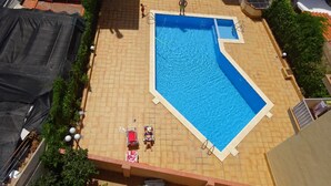A rooftop swimming pool with tiled flooring, surrounded by greenery and a few lounge chairs. - The only one with a pool in downtown Tossa. Beach 100 m away, sleeps 6, Wi-Fi, renovated (Tossa de Mar)