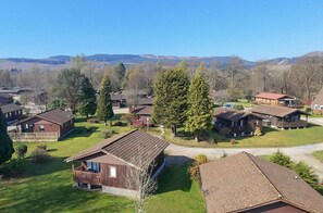 A residential area with multiple wooden cabins, each with a porch and surrounded by greenery.