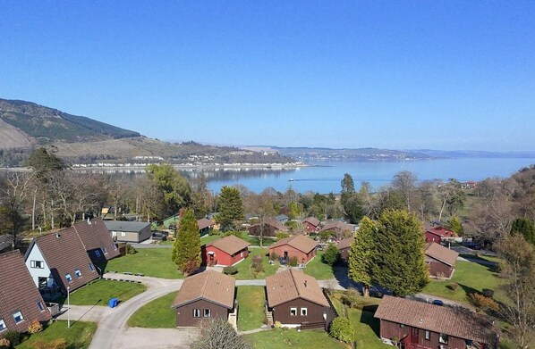 A residential area with houses, a lake, and hills in the background.