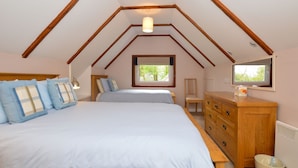 A bedroom with two beds, a wooden dresser, a chair, and a television. - Lovely cottage with loch views, near Dunoon, sleeps 6 (Blairmore)