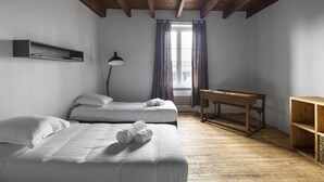 A room with two beds, a desk, a lamp, and a window with curtains. - L’Écume-Maison confortable et équipée (Saint-Coulomb)